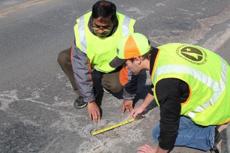 Manik Barman (left) measures a pothole with a University of Minnesota Duluth student.