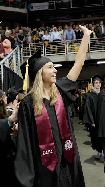 Amanda Fowler waving at family during commencement 