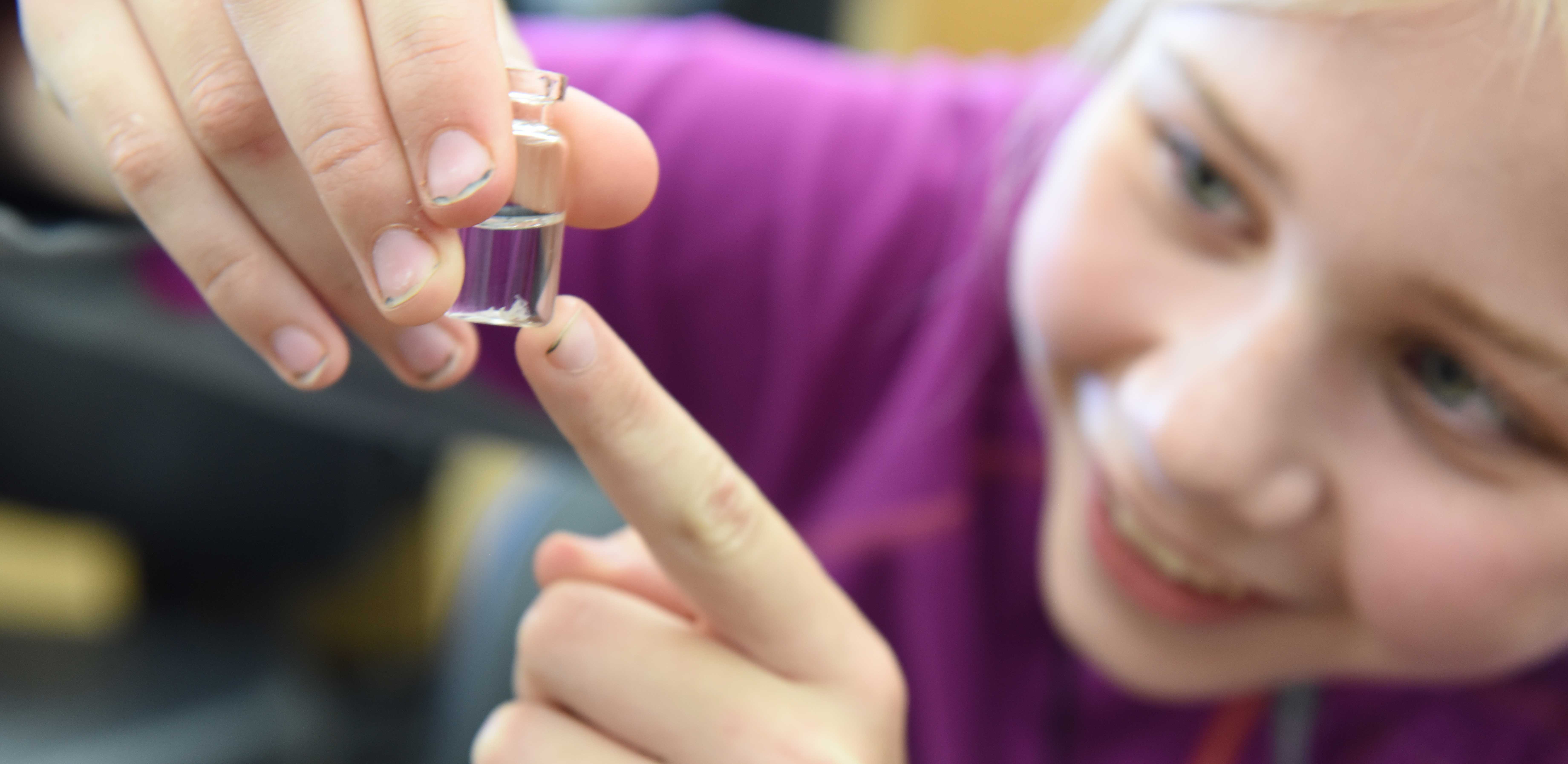 Girl looking at DNA in vial